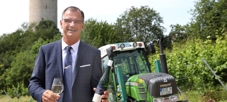 Bürgermeister Winfried Steinmacher am Weinberg der Ehe, im Hintergrund Burgruine Scharfenstein