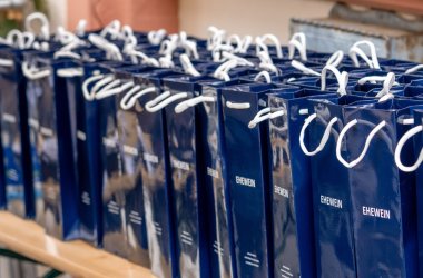 Ehepaar-Treffen 2026 Auf einer Bierzeltgarnitur stehen viele Weintüten in blau mit der Aufschrift "Ehewein".