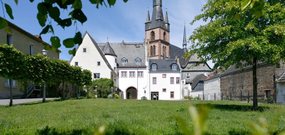 Josef-Staab-Platz Kiedrich mit Wiese und Bäumen mit Blick auf das Kiedricher Rathaus und die Kirche St. Valentinus und Dionysius