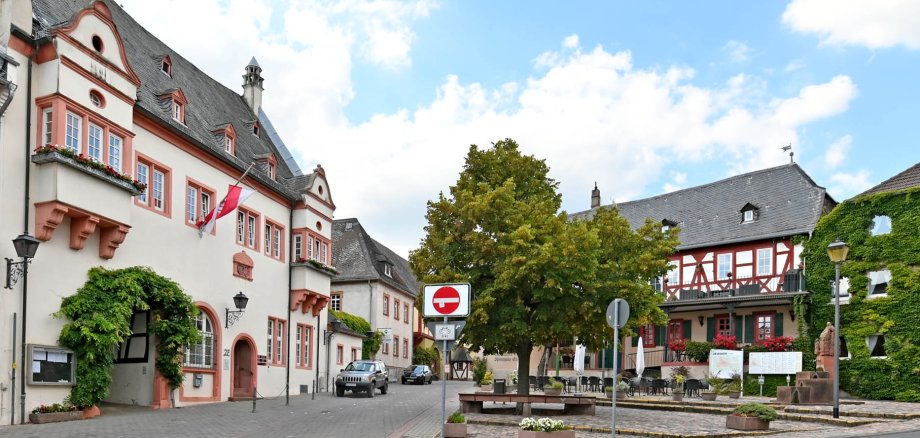 Kiedricher Marktplatz mit dem Rathaus, dem Marktbrunnen, Kopfsteinpflaster, dem Fachwerkhaus mit dem Gasthaus Engel und einem weiterem Haus mit Begrünung