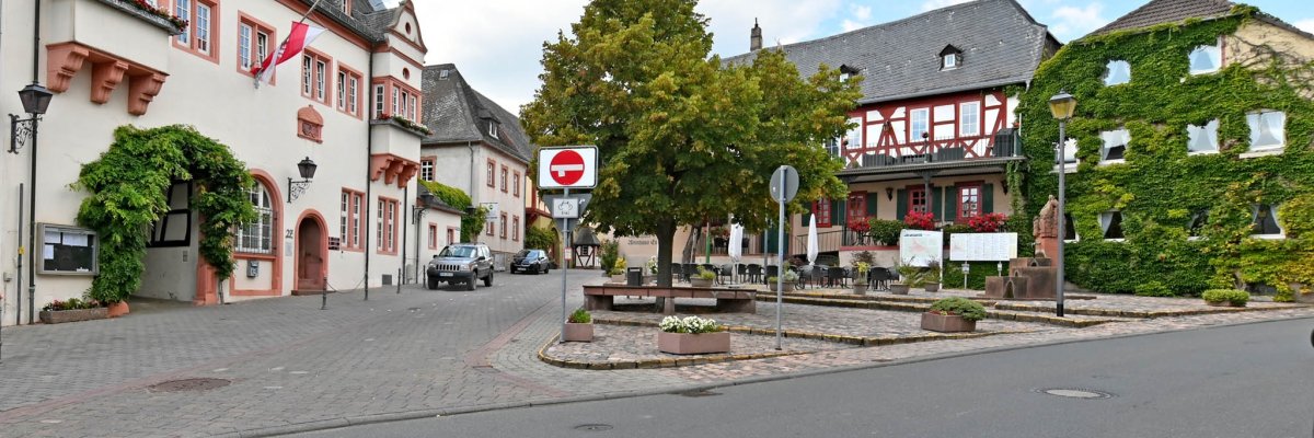 Kiedricher Marktplatz mit dem Rathaus, dem Marktbrunnen, Kopfsteinpflaster, dem Fachwerkhaus mit dem Gasthaus Engel und einem weiterem Haus mit Begrünung