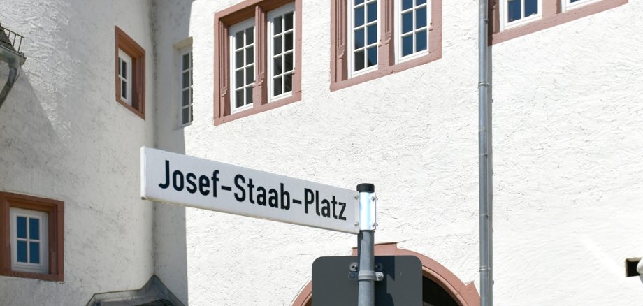 Josef-Staab-Platz mit Blick auf das Kiedricher Rathaus, einem weissen Gebäude mit sandsteinfarbenen Fensterrahmen