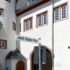 Josef-Staab-Platz mit Blick auf das Kiedricher Rathaus, einem weissen Gebäude mit sandsteinfarbenen Fensterrahmen