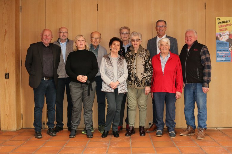 Neun Mitglieder des Seniorenbeirates und Herr Bürgermeister Steinmacher stehen vor Holztüren. 