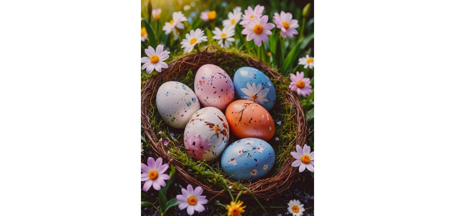 Sechs bunte Eier, mit Sprenkeln und weißen Blumen und braunen Ästen bemalt, liegen in einem Osternest mit Zweigen und Moos. Drum herum sind weiße und rosa Gänseblümchen.
