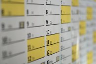 Kalender Ausschnitt eines Wandkalenders, auf dem die Zahlenen und dahinter etwas kleiner die ersten beiden Anfangsbuchstaben der Wochentage in schwarz gedruckt sind. Darunter ist ein schwarzer Strich. Die Felder am Wochenende sind gelb gefüllt.
