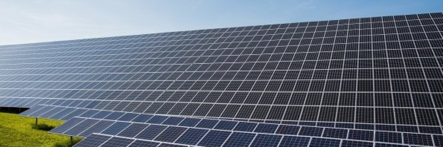 Ein Feld von Solarpanel steht auf einer Wiese.