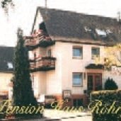 Beiges Haus mit zwei Balkonen mit bepflanzten Blumenkästen