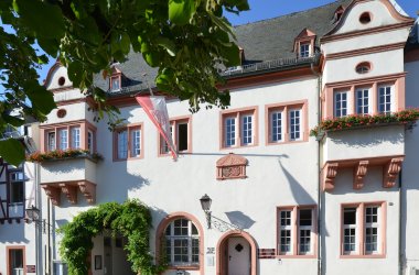 Kiedricher Rathaus, weisses Gebäude mit Sandsteinfensterrahmen und Fahne mit Kiedricher Wappen in rot und weiss