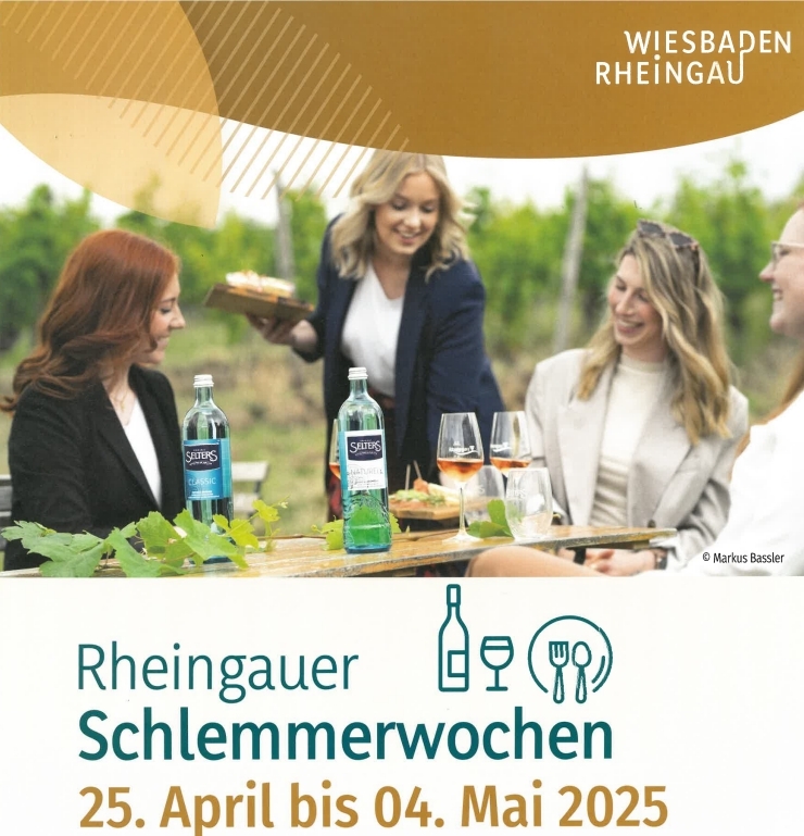 Plakatwerbung für Rheingauer Schlemmerwochen- Drei Frauen im Blazer sitzen an einem Tisch in den Weinbergen und eine Frau im Blazer reicht zwei Brettchen mit Essen an. Auf dem Tisch stehen Wasserglasflaschen und drei mit Rose gefüllte Weingläser und ein Wasserglas sowie Blätter eines Weinstocks.