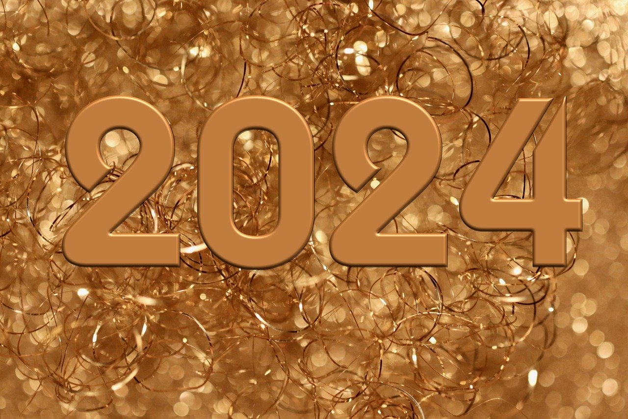 Goldene Zahl 2024 auf goldenen Luftschlangen.