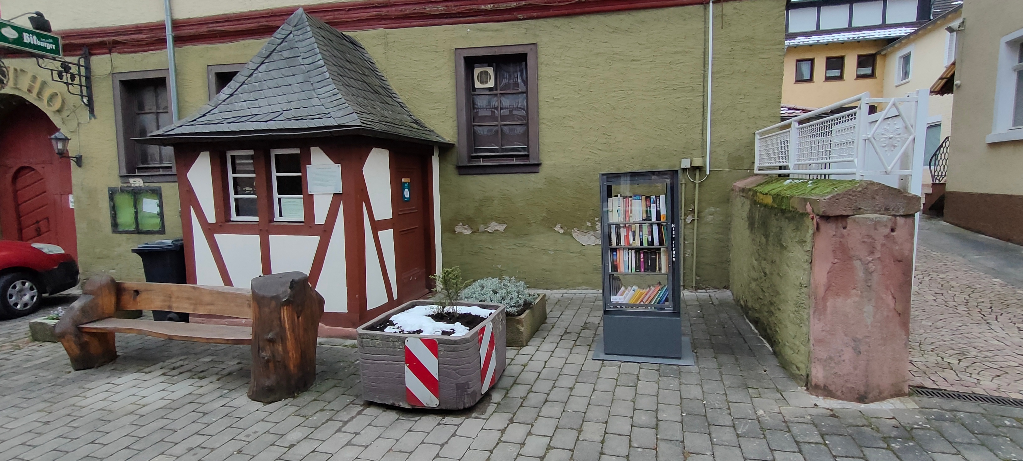 Bücherschrank aus Metall und Glas gefüllt mit Büchern.