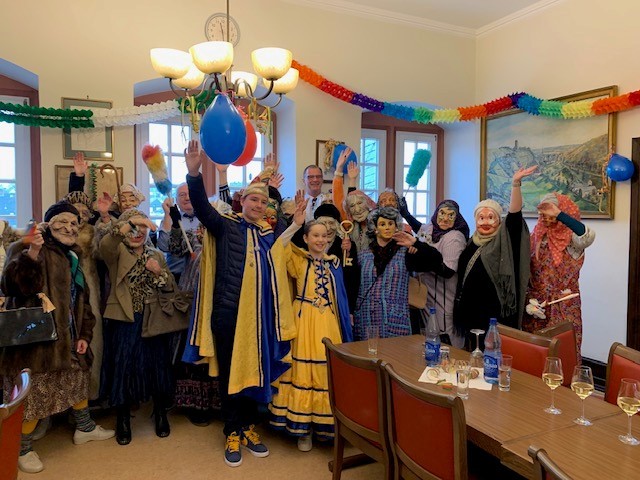 Verkleidete Frauen mit Bügermeister und Prinzenpaar im geschmückten Rathaussaal.