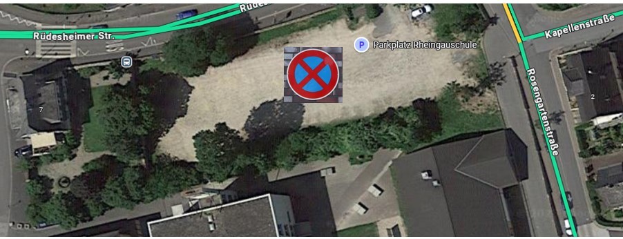 Satellit-Luftbild mit einem Parkverbotsschild auf dem grauem Schotterplatz.