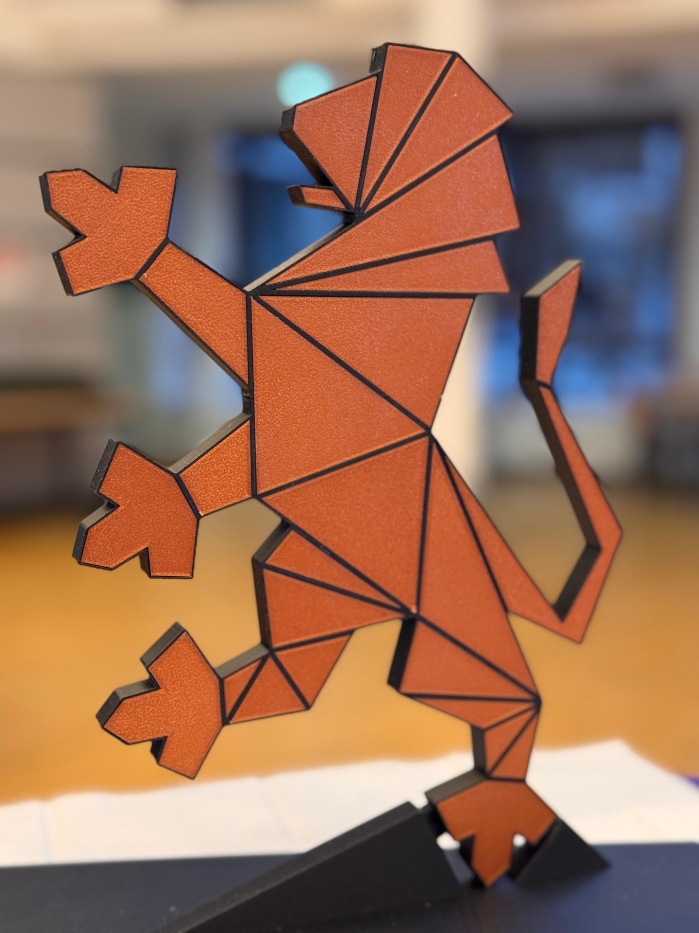 Der hessische Löwe, der auf einer Pfote aufrecht steht ist hellbraun und hat dunkle Striche, die Flächen abgrenzen.