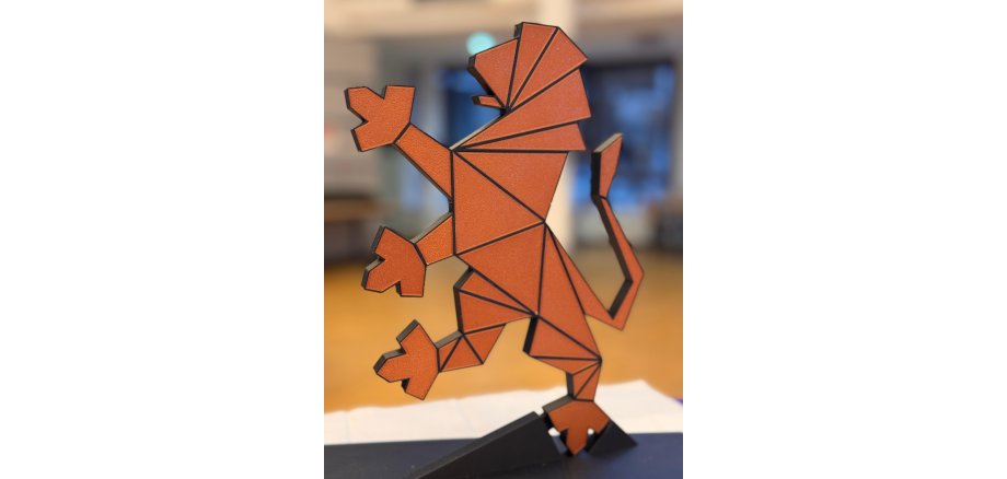 Der hessische Löwe, der auf einer Pfote aufrecht steht ist hellbraun und hat dunkle Striche, die Flächen abgrenzen.