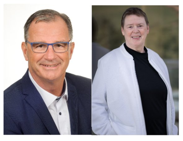 Links ein Portrait des Bürgermeister Winfried Steinmacher. Er trägt ein blaues Sakko und ein weißes Hemd mit blauen Knöpfen. Er hat kurze grau-braune Haare und eine blaue Brille. Rechts davon das Portrait der Vorsitzenden der Gemeindevertretung Beate Schmidt. Sie trägt einen schwarzen Rollkragenpullover und eine weiße Jacke mit Reisverschluss darüber, die sie offen trägt. Sie hat braunes kurzes Haar.