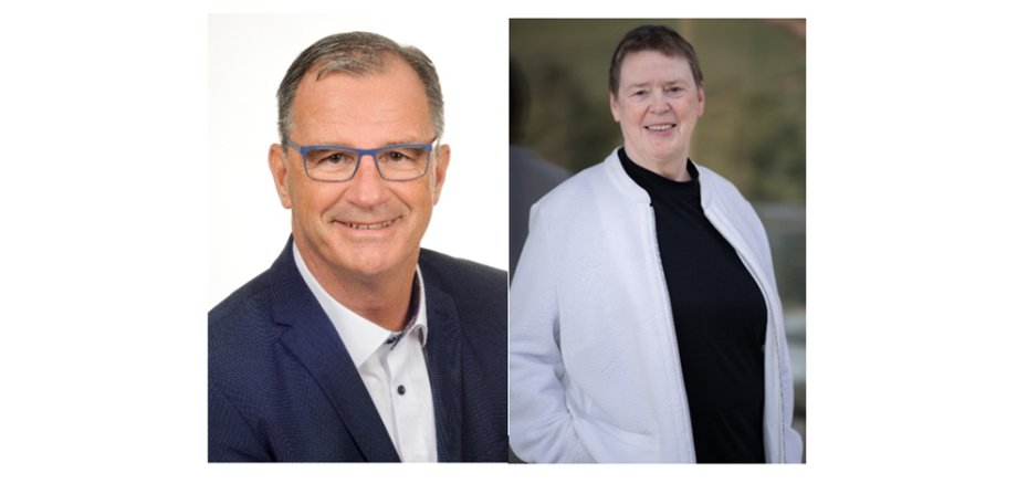 Links ein Portrait des Bürgermeister Winfried Steinmacher. Er trägt ein blaues Sakko und ein weißes Hemd mit blauen Knöpfen. Er hat kurze grau-braune Haare und eine blaue Brille. Rechts davon das Portrait der Vorsitzenden der Gemeindevertretung Beate Schmidt. Sie trägt einen schwarzen Rollkragenpullover und eine weiße Jacke mit Reisverschluss darüber, die sie offen trägt. Sie hat braunes kurzes Haar.