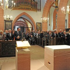 Blick vom Altar aus in den voll besetzten Kirchenraum mit in den Bänken stehenden Kirchenbesuchern.